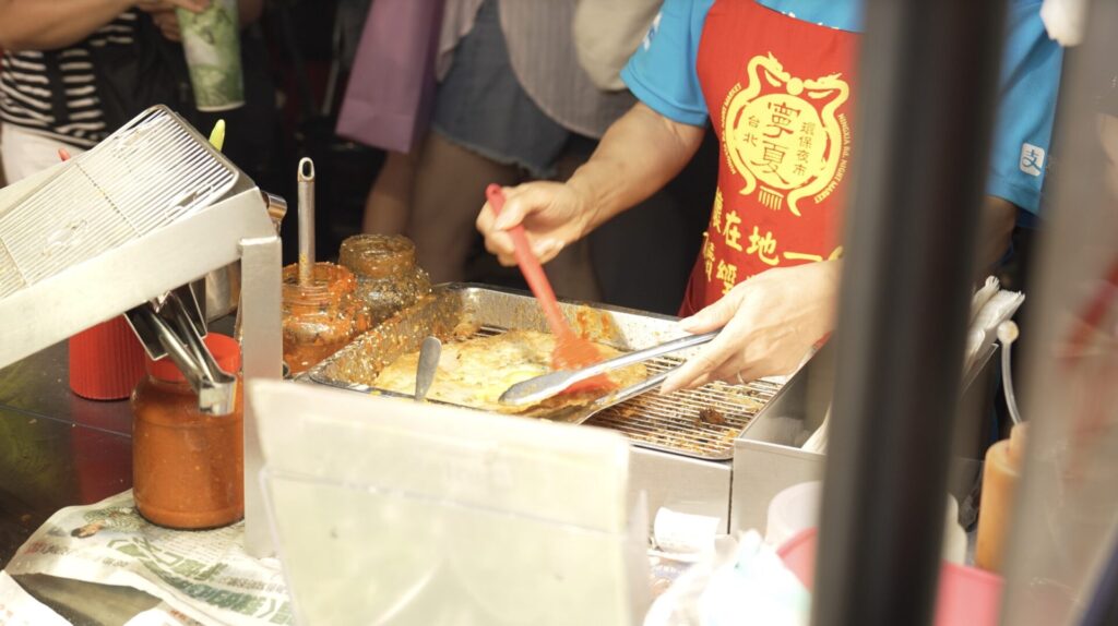 葱油餅にソースを塗る様子